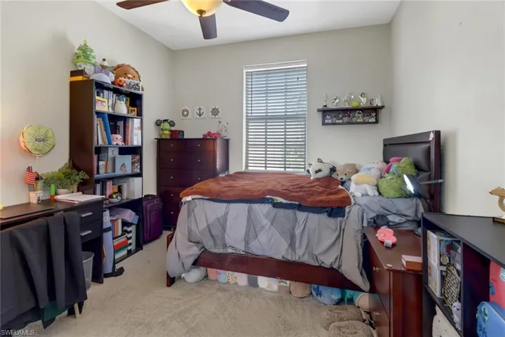 Bedroom featuring light colored carpet and ceiling fan