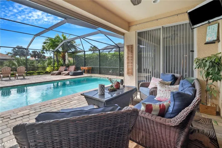View of pool with a patio and glass enclosure