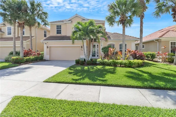 View of front of property featuring french doors, a front yard, and a garage