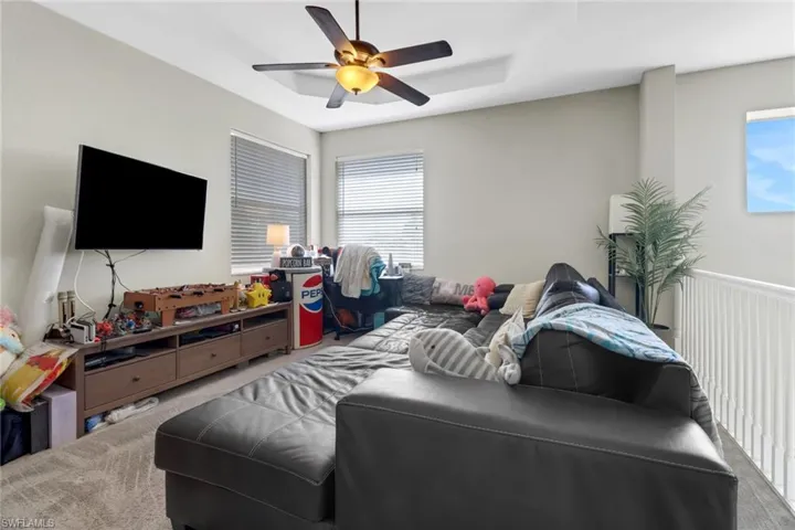 Carpeted bedroom featuring ceiling fan
