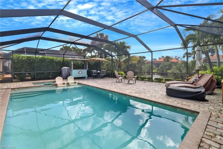 View of swimming pool with a patio and glass enclosure