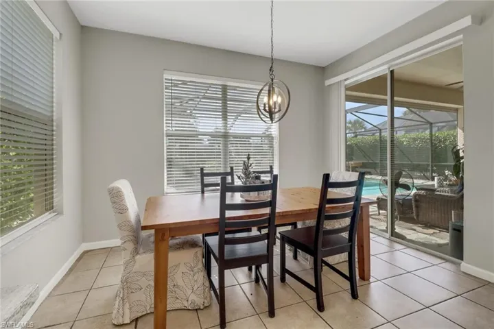 Dining space with a chandelier, plenty of natural light, and light tile patterned floors