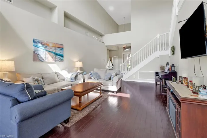 Living room featuring a high ceiling and dark hardwood / wood-style flooring