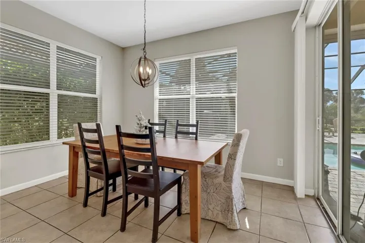 Tiled dining room featuring a wealth of natural light and a notable chandelier