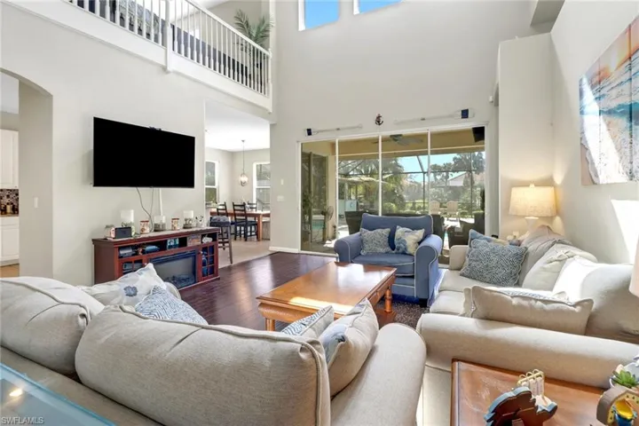 Living room featuring a high ceiling and wood-type flooring