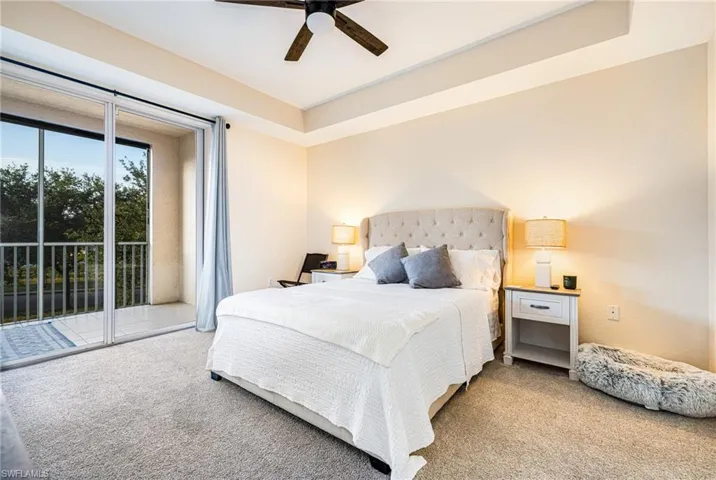 Carpeted bedroom with access to exterior and a ceiling fan