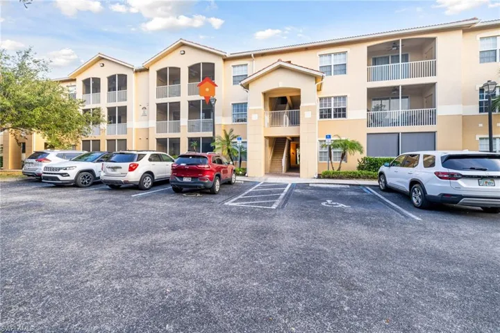 View of apartment building / complex featuring uncovered parking