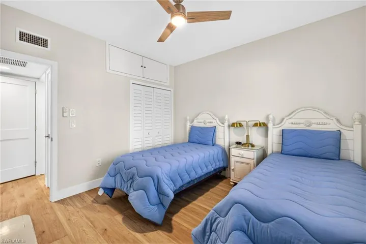 Bedroom with wood finished floors, a closet, and a ceiling fan