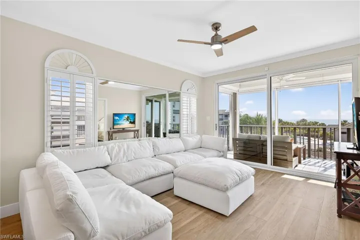 Living area with light wood-style floors, crown molding, and a ceiling fan