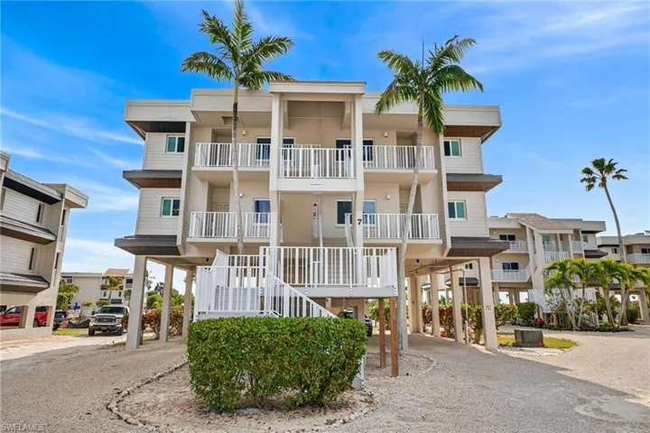 View of apartment building / complex with a carport and driveway