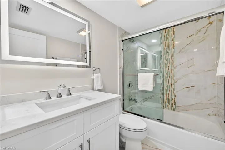 Full bath with vanity and shower / bath combination with glass door