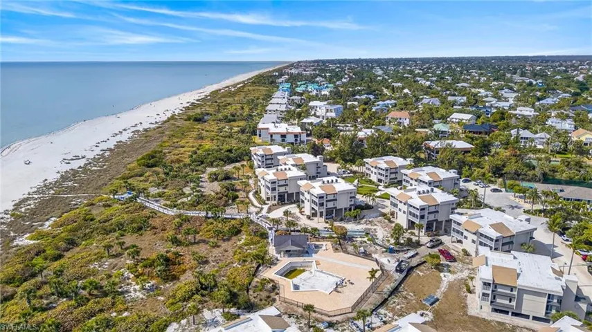 Aerial view of property's location featuring waterfront with a beach