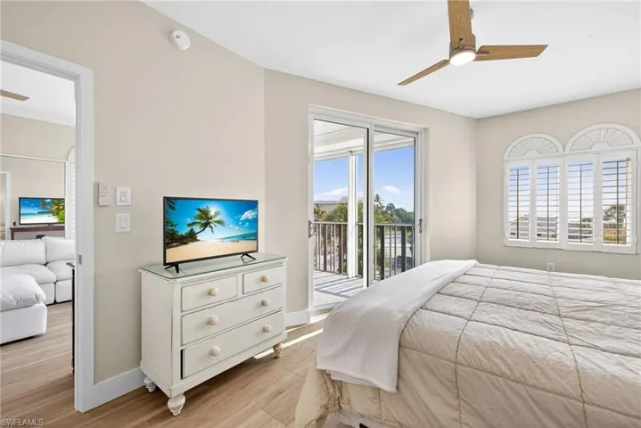 Primary Bedroom featuring light wood-style flooring, access to exterior, and ceiling fan