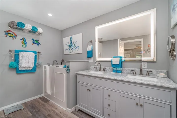 OWNER'S SUITE BATH W/DUAL SINK GRANITE-TOPPED VANITY.  LIGHTED MIRROR.  WALK-IN TUB.