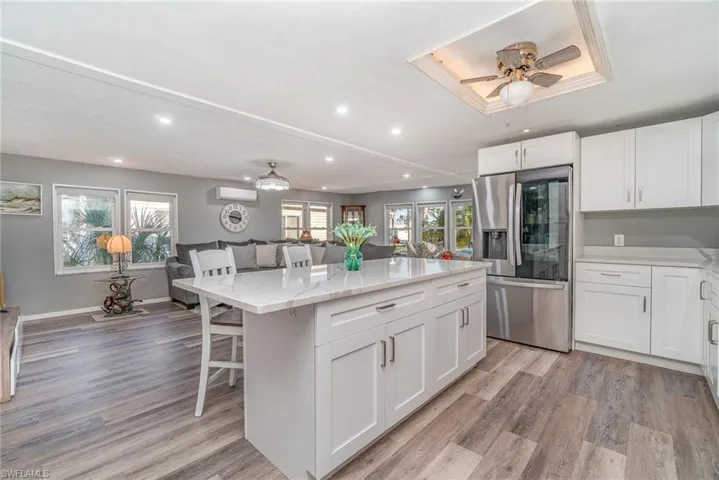 VIEW FROM ENTRANCE INTO KITCHEN AND MAIN LIVING AREA.  RECESSED LIGHTING THROUGHOUT.  LIGHTED TRAY CEILING.  SLIT AC (& HEATING) UNIT.  IMPACT RESISTANT WINDOWS.