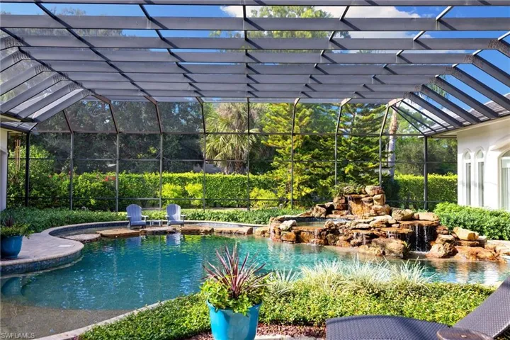 Outdoor pool with glass enclosure, a sunroom, and a patio