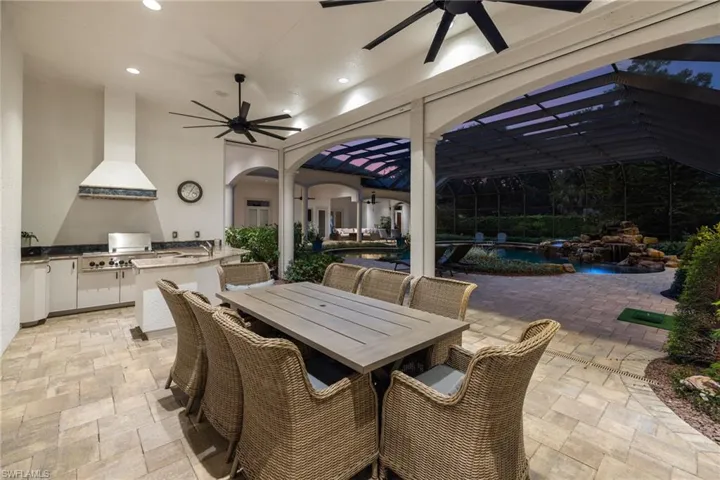 View of patio with ceiling fan, outdoor dining area, area for grilling, and an outdoor pool
