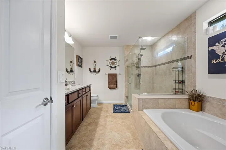 Primary bath with soaking tub and stand up shower with custom tile accents.