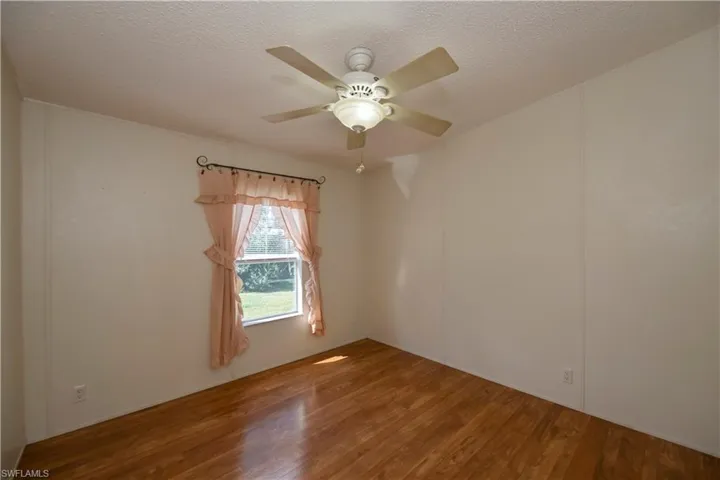 Spare room featuring ceiling fan, hardwood / wood-style floors, and a textured ceiling