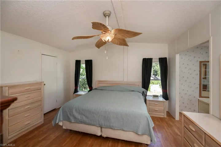 Bedroom featuring ceiling fan, a textured ceiling, light wood-type flooring, and a closet