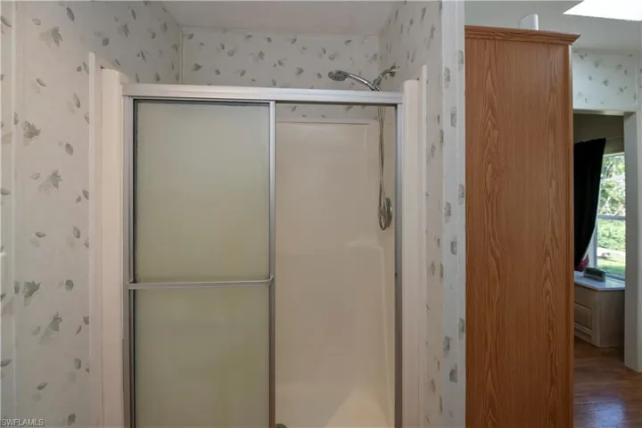 Bathroom with hardwood / wood-style floors and a shower with shower door