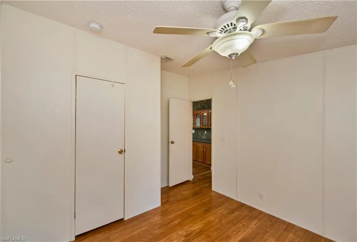 Unfurnished bedroom featuring a textured ceiling, hardwood / wood-style floors, and ceiling fan