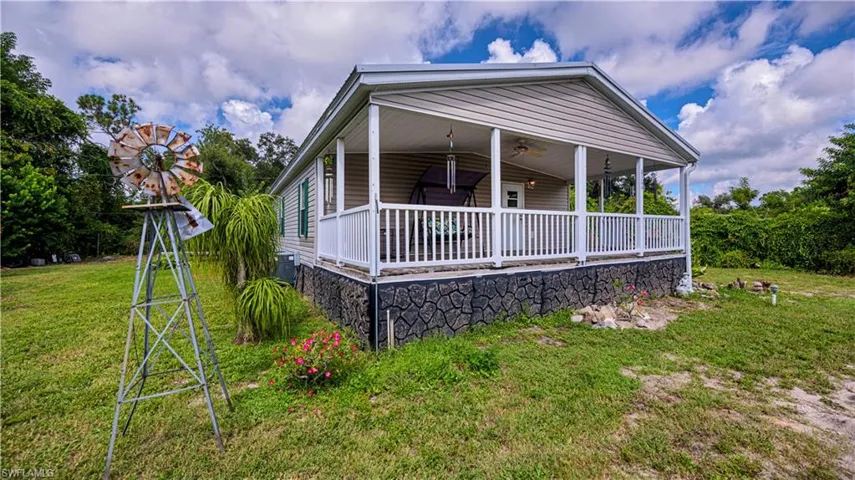 View of front facade with ceiling fan and a front yard