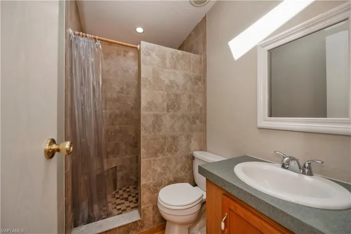 Bathroom featuring vanity, toilet, and a shower with shower curtain