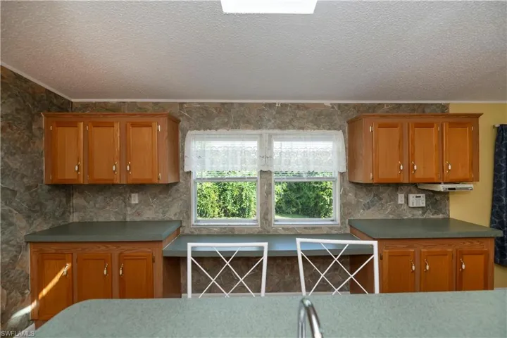 Kitchen featuring a textured ceiling and crown molding