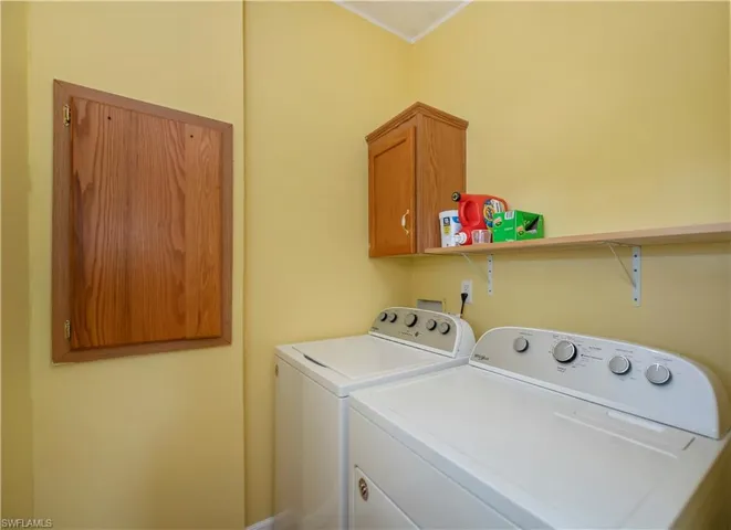 Laundry room with separate washer and dryer and cabinets