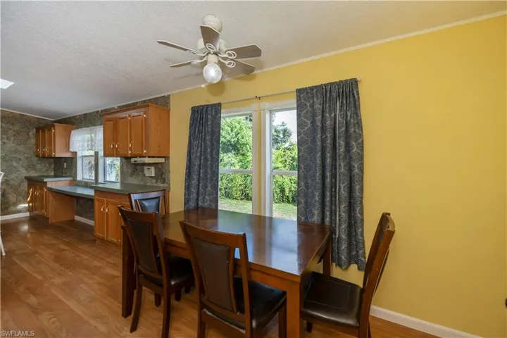 Dining space featuring crown molding, ceiling fan, hardwood / wood-style flooring, and a textured ceiling