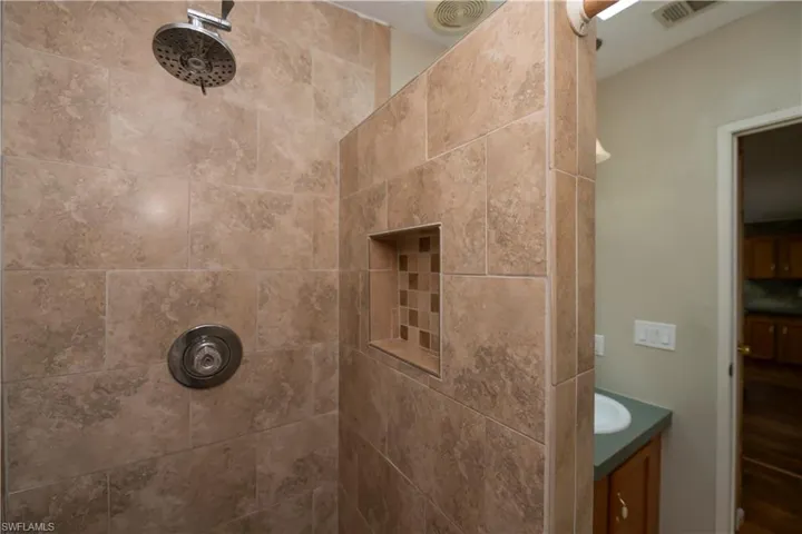 Bathroom featuring vanity and tiled shower