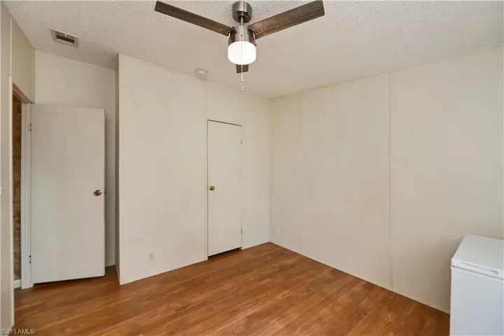 Spare room with a textured ceiling, ceiling fan, and hardwood / wood-style flooring