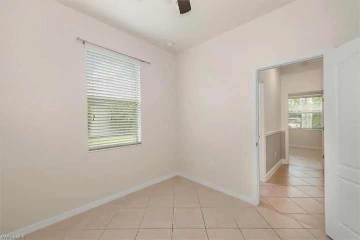Original view of bedroom 3 with tile flooring, neutral finishes, and ceiling fan.