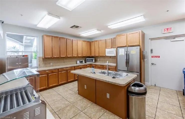 Community kitchen with granite island, wood cabinetry and serving space for events.
