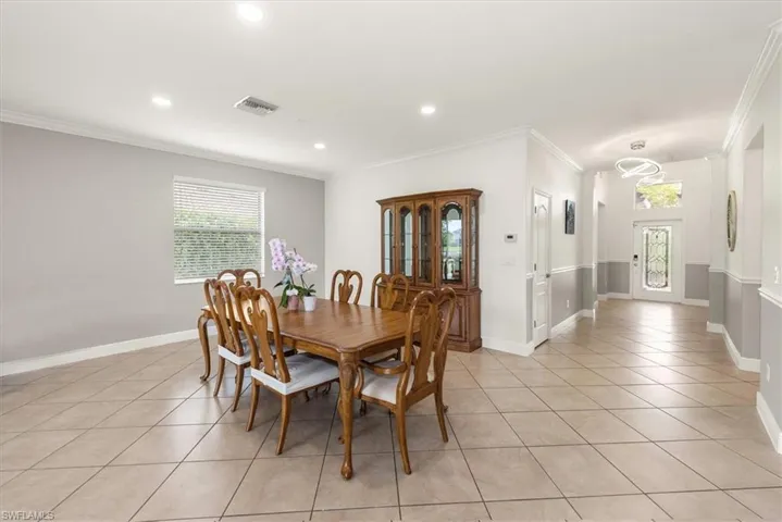 Spacious dining area featuring tile flooring, crown molding, window with blinds, and recessed lighting.