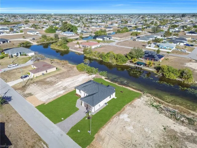 Aerial view of residential area featuring a nearby body of water