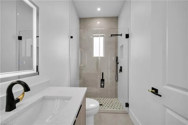 Guest bathroom with vanity, a shower stall, recessed lighting, and light tile patterned floors