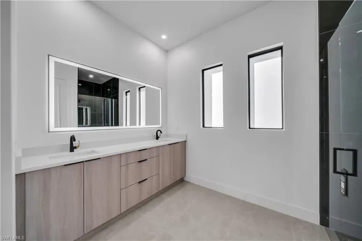 Master Bathroom with a shower stall, double vanity, recessed lighting, and light tile patterned floors