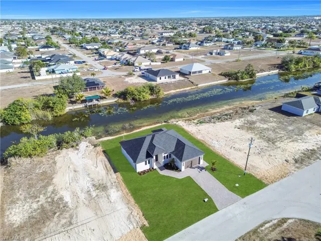 Aerial perspective of suburban area featuring a nearby body of water