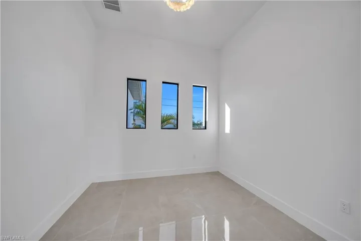 Spare room with baseboards and light tile patterned flooring