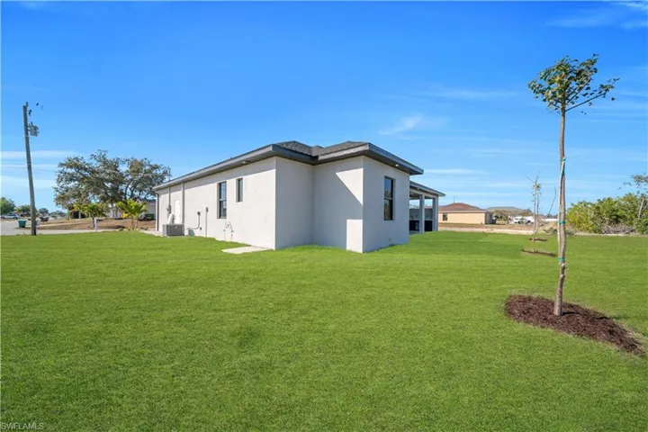 View of property exterior with a yard and stucco siding