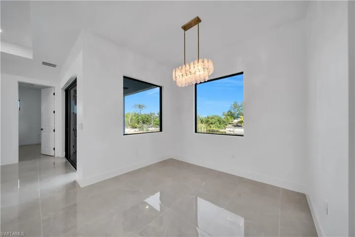 Empty room with a chandelier and baseboards