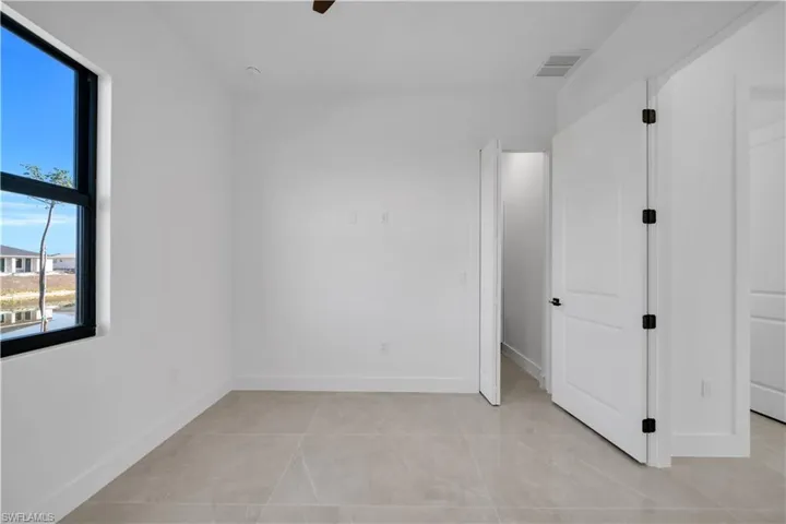 Unfurnished bedroom featuring ceiling fan and light tile patterned flooring