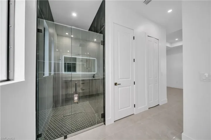 Bathroom featuring a stall shower, recessed lighting, a closet, and light tile patterned floors
