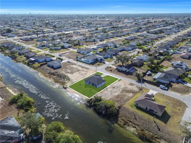 Aerial view of property and surrounding area with a nearby body of water and nearby suburban area