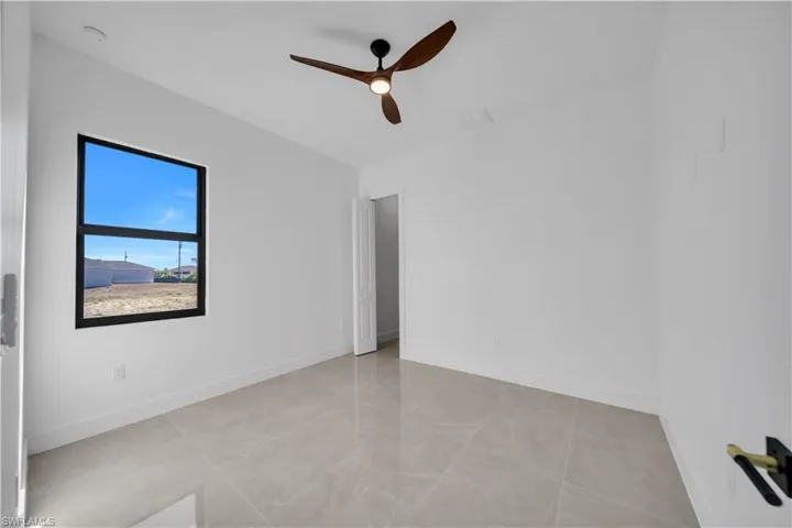 Spare room with ceiling fan and baseboards