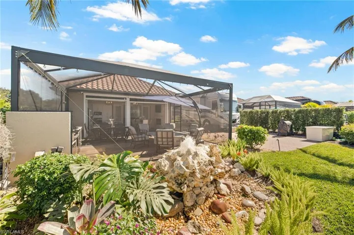 Rear view of property featuring glass enclosure, a patio area, a sunroom, and stucco siding