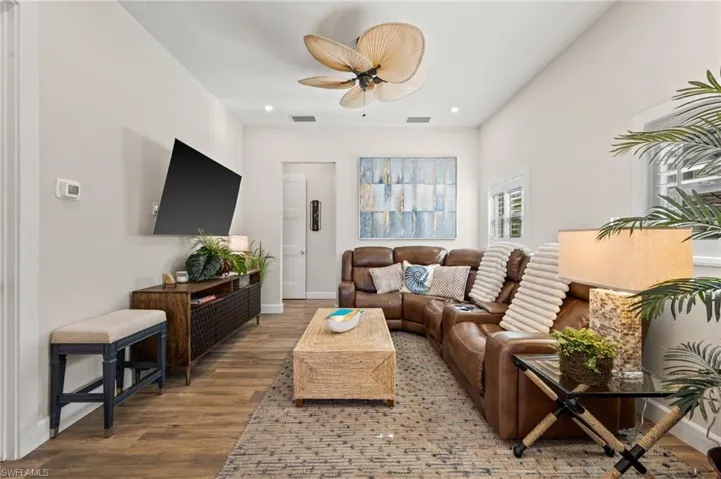 Living room with wood finished floors, a ceiling fan, and recessed lighting