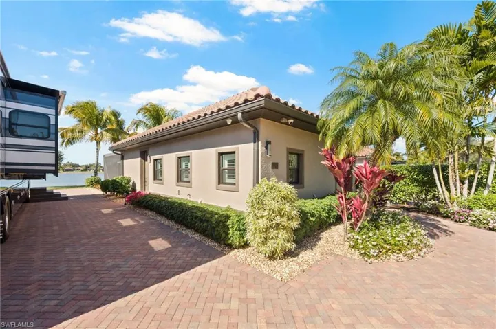View of side of property with stucco siding and a tile roof